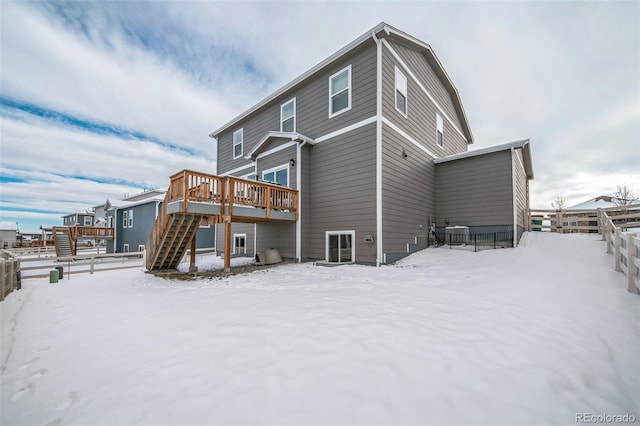 snow covered rear of property with a wooden deck