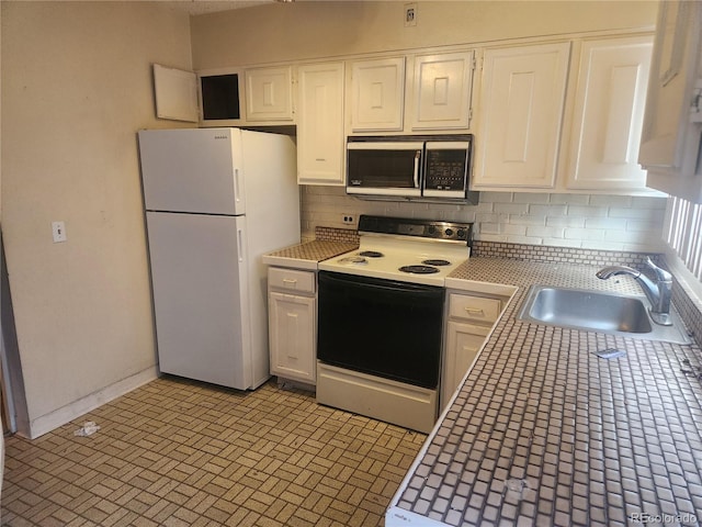 805 E 7th Ave Unit 8, Denver, CO 80218 - kitchen with range with electric cooktop, freestanding refrigerator, a sink, backsplash, and white cabinets