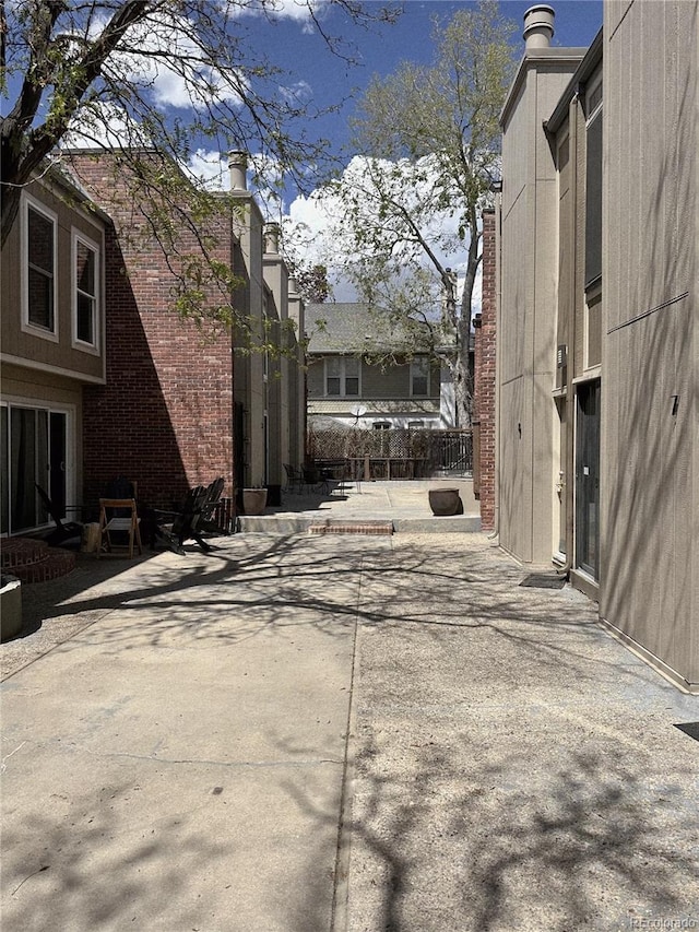805 E 7th Ave Unit 8, Denver, CO 80218 - view of property exterior featuring a patio, a chimney, and brick siding