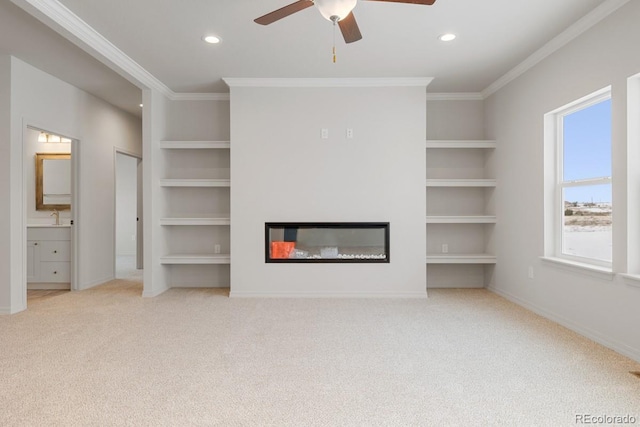 unfurnished living room featuring ornamental molding, light carpet, and built in shelves