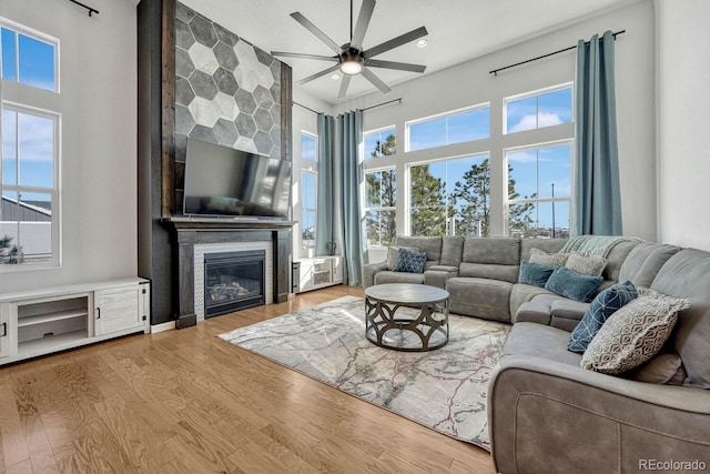 living room featuring a fireplace, hardwood / wood-style floors, and ceiling fan