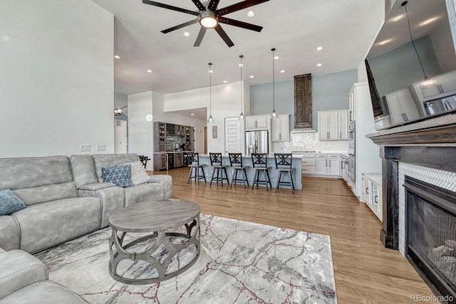 living room with ceiling fan and light wood-type flooring