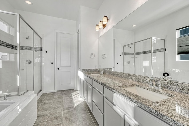 bathroom with a shower with door, vanity, and tile patterned flooring