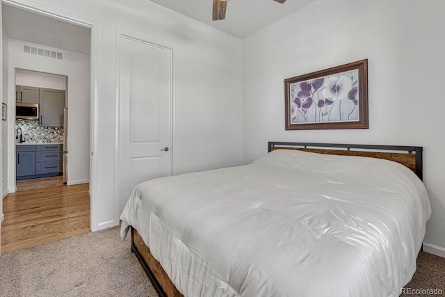 carpeted bedroom featuring ensuite bathroom and ceiling fan