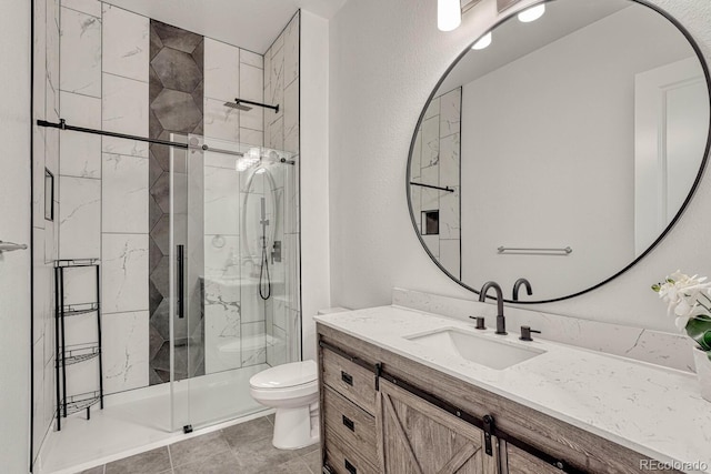 bathroom with vanity, toilet, and a shower with door