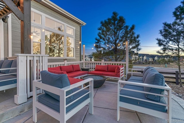 patio terrace at dusk featuring an outdoor living space with a fire pit