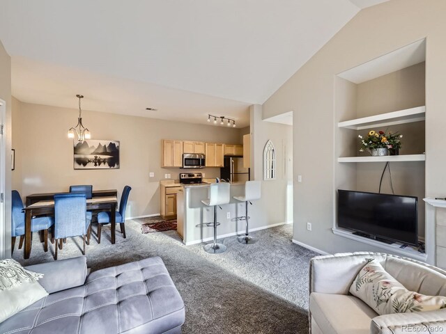 8481 W Union Ave Unit 4-203, Littleton, CO 80123 - living room featuring built in shelves, lofted ceiling, carpet flooring, and a chandelier