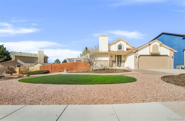 view of front of property with a garage, stucco siding, fence, a front lawn, and driveway