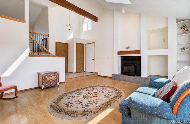 living room with built in features, baseboards, stairway, and wood finished floors