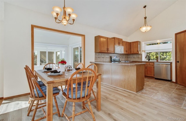 dining space with a chandelier, baseboards, vaulted ceiling, and light wood-style flooring