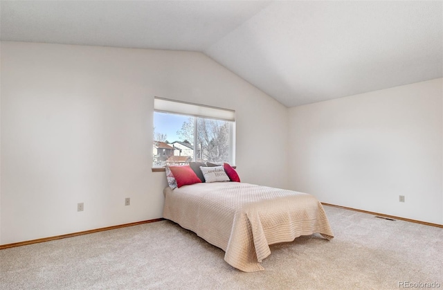 carpeted bedroom featuring baseboards and vaulted ceiling
