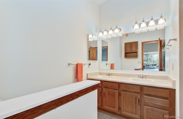 full bath with double vanity, a sink, and connected bathroom