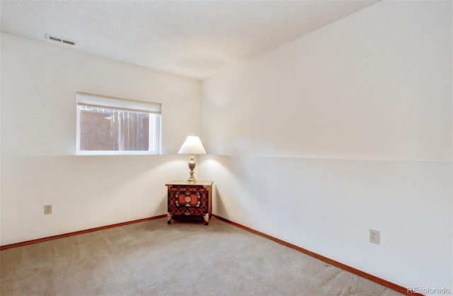 carpeted empty room with visible vents and baseboards