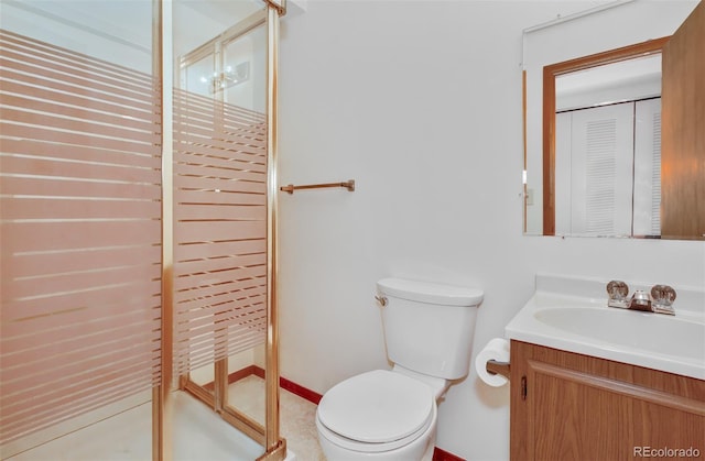 bathroom with toilet, a stall shower, and vanity