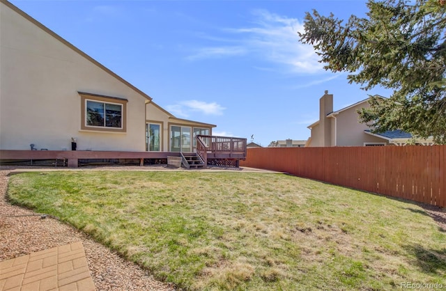 view of yard with fence and a deck