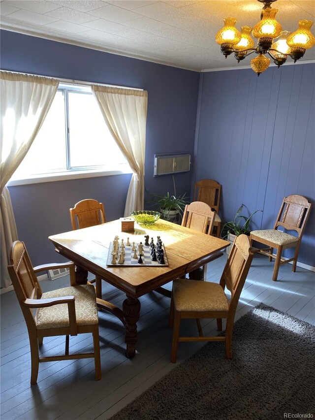 dining space with a textured ceiling, an inviting chandelier, and hardwood / wood-style flooring