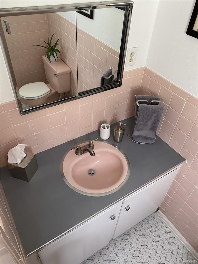 bathroom featuring tile patterned floors, tile walls, vanity, and toilet