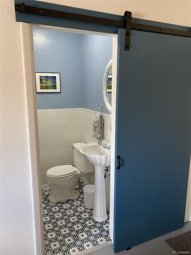 bathroom with tile walls, tile patterned flooring, and toilet