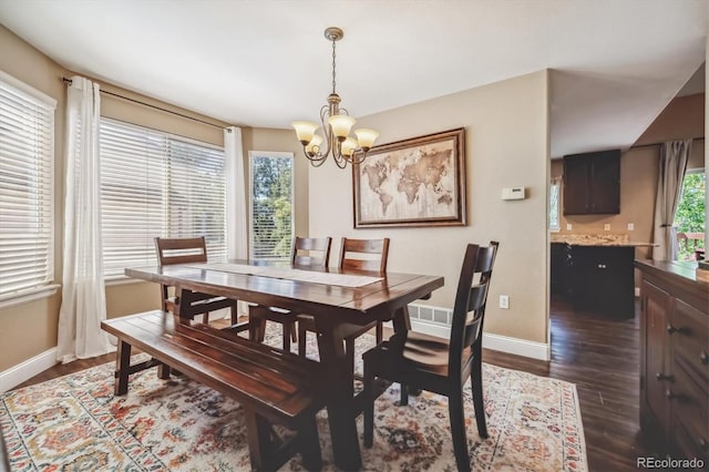 dining area with dark hardwood / wood-style flooring and a chandelier