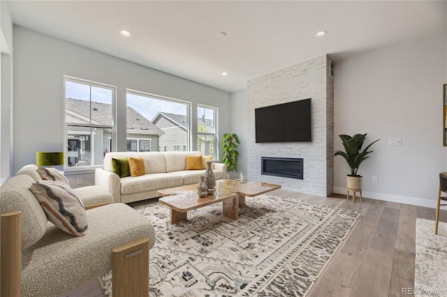 living room with a fireplace and light wood-type flooring