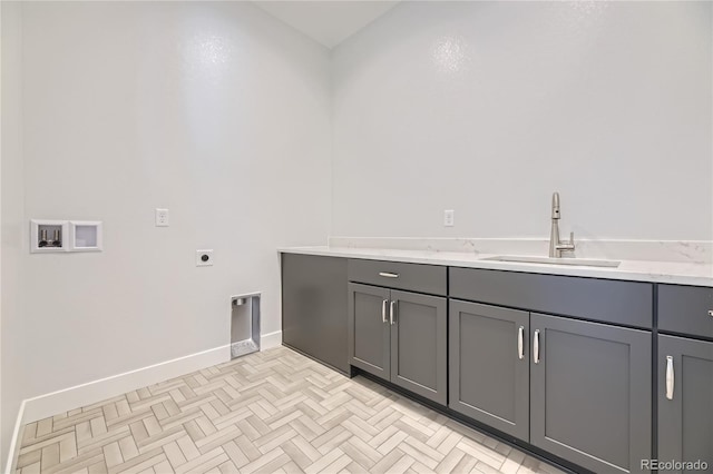 washroom featuring sink, hookup for a washing machine, hookup for an electric dryer, and cabinets