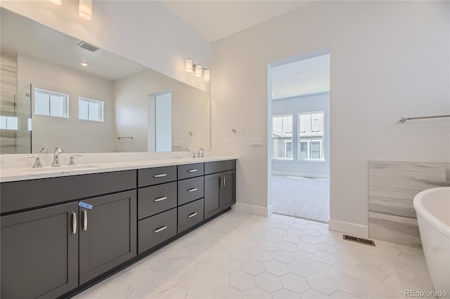 bathroom with a shower, tile patterned flooring, and vanity