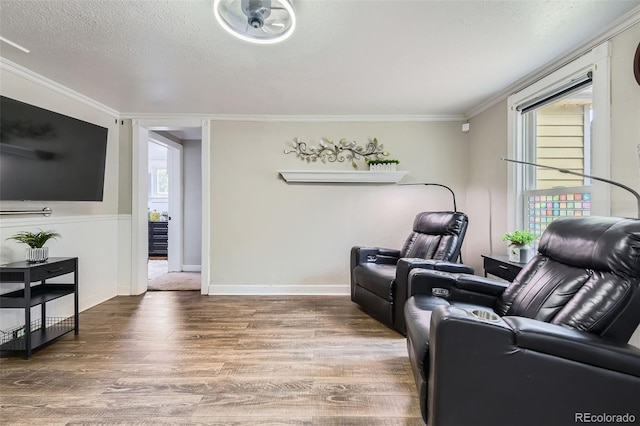 living room featuring wood finished floors, crown molding, and a textured ceiling