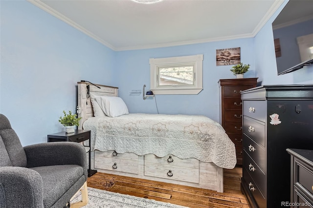 bedroom with crown molding and wood finished floors