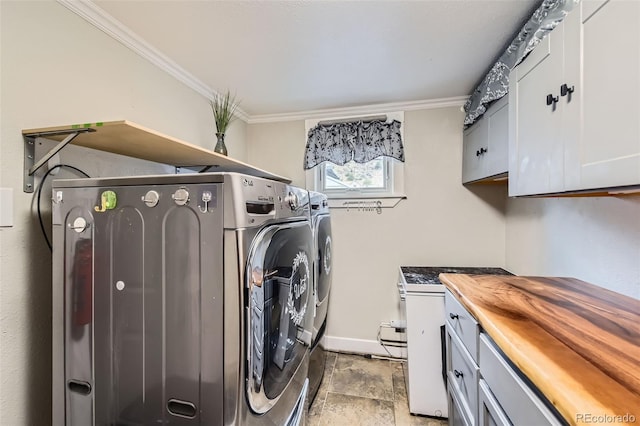 laundry area featuring washer and dryer, cabinet space, crown molding, baseboards, and light stone finish flooring
