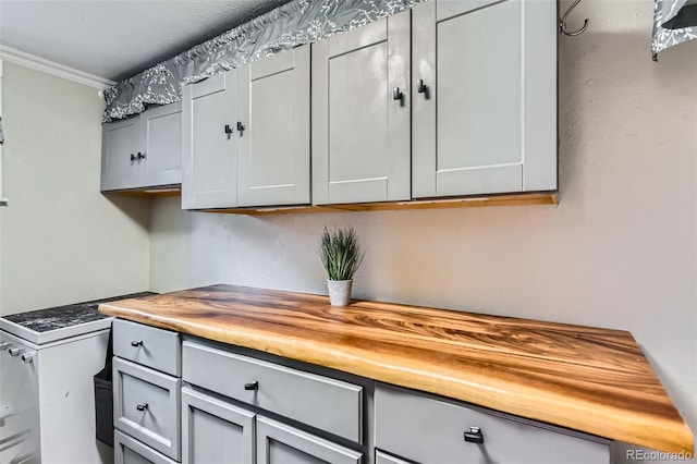 kitchen featuring gray cabinets, butcher block countertops, and ornamental molding