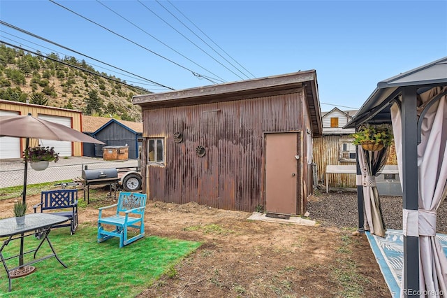 view of outbuilding with fence and an outbuilding