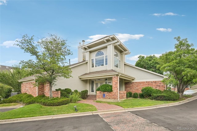 13873 E Lehigh Ave Unit C, Aurora, CO 80014 - view of front property with brick siding, a front yard, and a chimney
