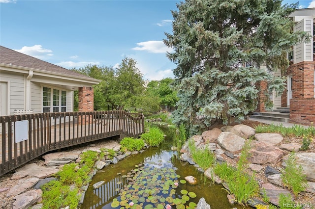 13873 E Lehigh Ave Unit C, Aurora, CO 80014 - view of yard with a small pond and a wooden deck
