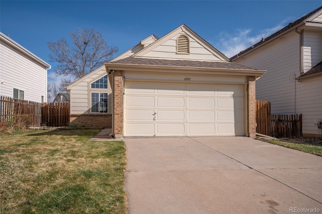 12977 W Dorado Pl, Littleton, CO 80127 - view of front of property featuring fence, concrete driveway, a shingled roof, a front yard, and brick siding