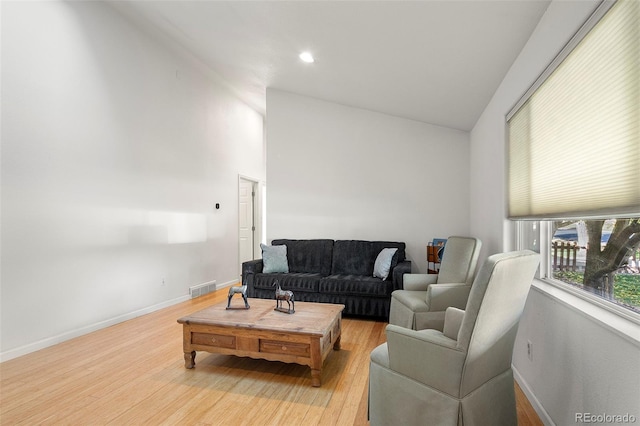 living room with light hardwood / wood-style flooring and lofted ceiling