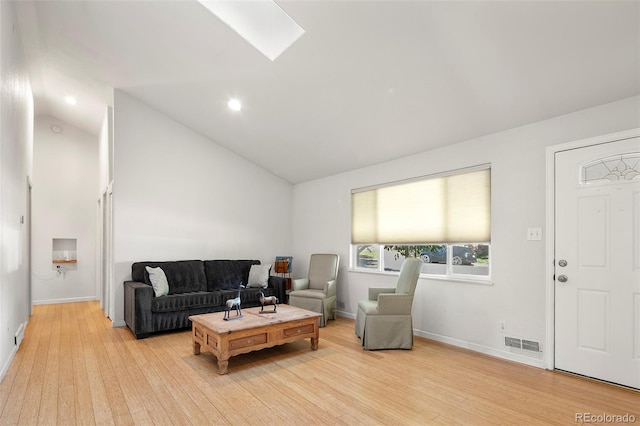 living room featuring a skylight, visible vents, baseboards, and light wood-style floors