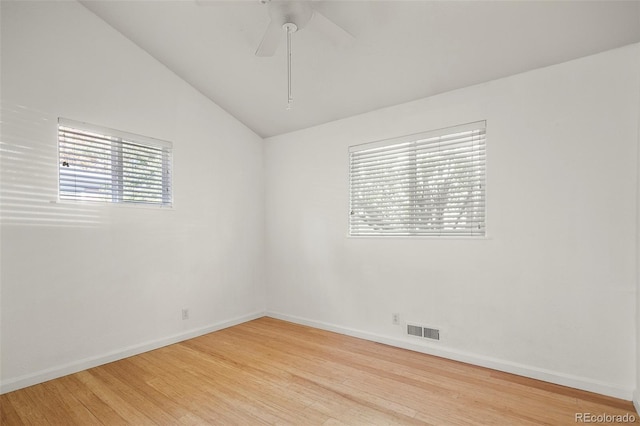 unfurnished room with visible vents, baseboards, light wood finished floors, and lofted ceiling