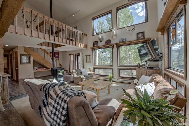 311 Longs Rd, Silverthorne, CO 80498 - living room with a high ceiling, carpet flooring, healthy amount of natural light, and a wood stove