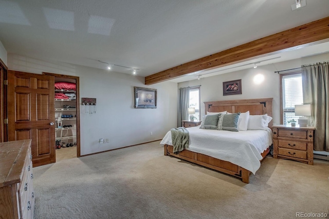 311 Longs Rd, Silverthorne, CO 80498 - bedroom with light colored carpet, multiple windows, a walk in closet, beam ceiling, and baseboards