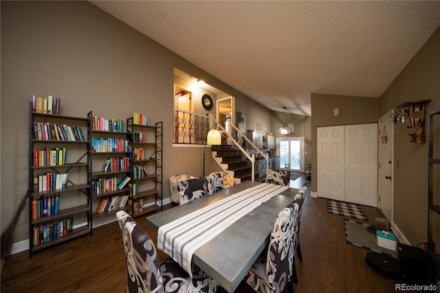 dining space featuring lofted ceiling, dark wood-type flooring, and a textured ceiling