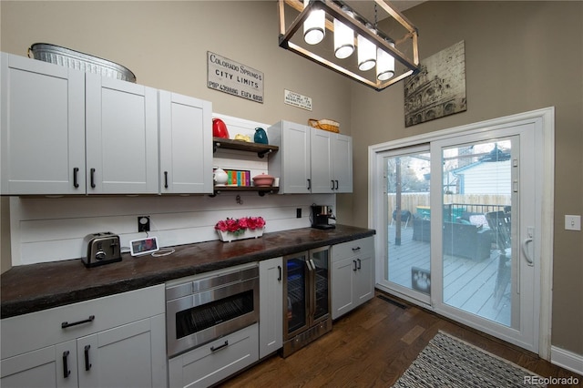 kitchen featuring white cabinetry, butcher block counters, stainless steel microwave, and beverage cooler