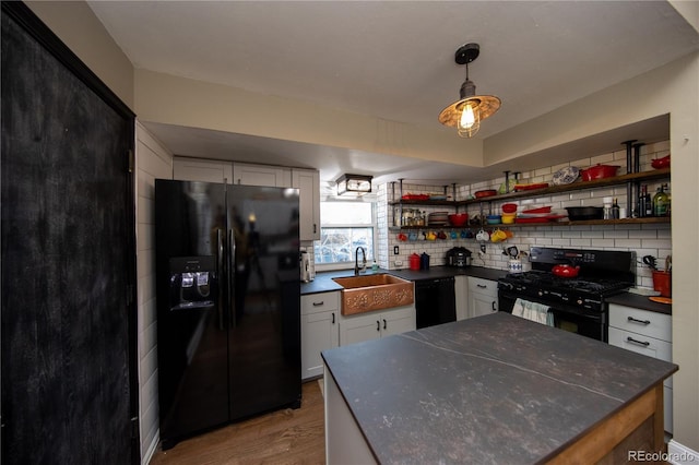 kitchen with sink, tasteful backsplash, black appliances, hardwood / wood-style flooring, and white cabinets