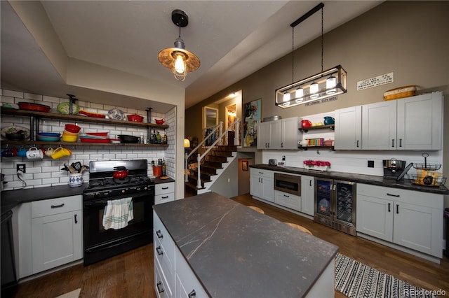 kitchen featuring backsplash, white cabinets, beverage cooler, and black gas range oven