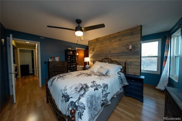 bedroom featuring ceiling fan, a textured ceiling, and light wood-type flooring