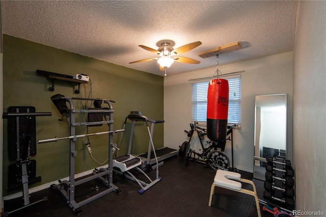 exercise area with ceiling fan and a textured ceiling