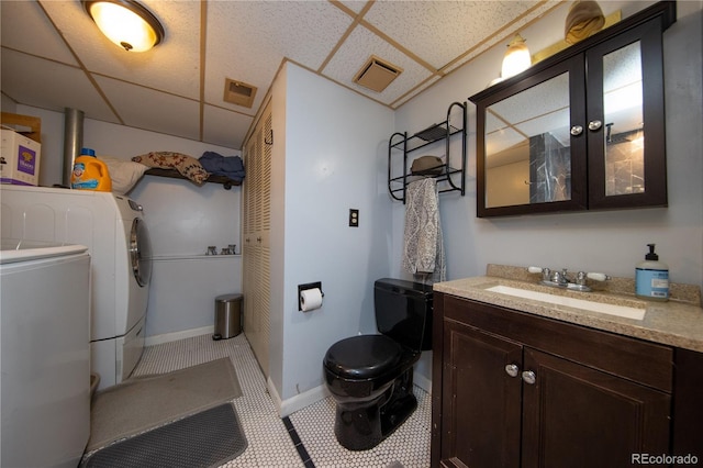 bathroom with vanity, a drop ceiling, and tile patterned floors