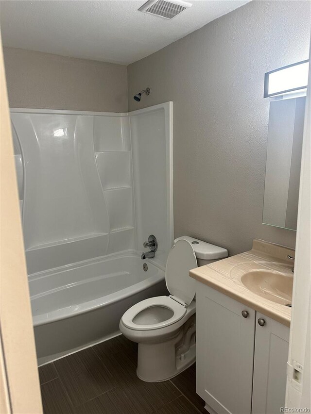 full bathroom with vanity, washtub / shower combination, and toilet