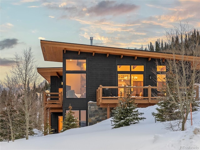 contemporary home with stone siding and a balcony