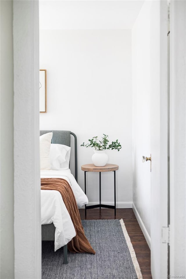 bedroom with baseboards and wood finished floors