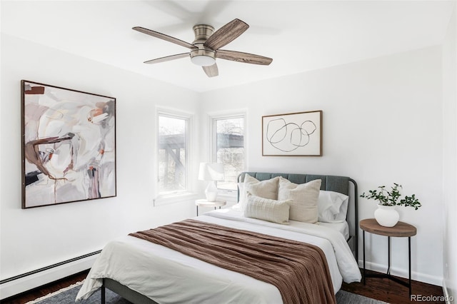 bedroom with wood finished floors, baseboards, baseboard heating, and ceiling fan